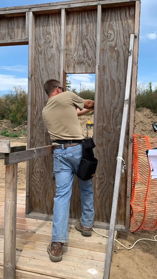 Member shooting through a range bay window